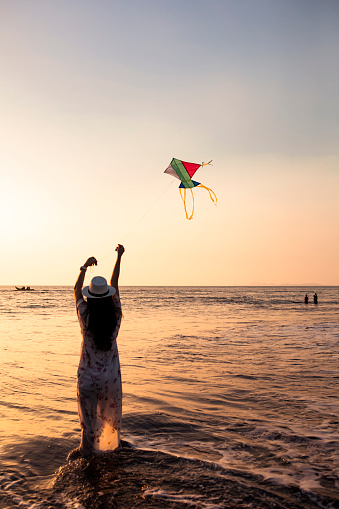 asian adult playing kite on the beach