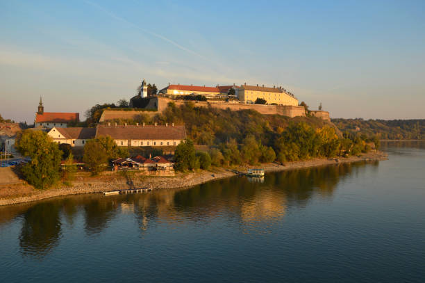 panoramic view of the Petrovaradin Fortress in bright autumn day Petrovaradin fortress reflected in Danube river in sunlight with blue sky Petrovaradin stock pictures, royalty-free photos & images