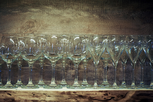 Row of empty wine glasses on vintage wooden background