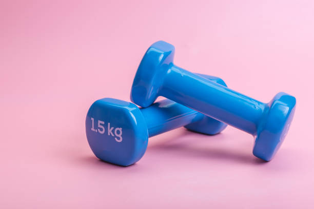istock A pair of blue dumbbells on a pink background 1263409283