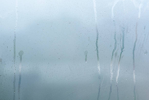 ventana con condensación de vapor y gotas después de la lluvia, vidrio húmedo como fondo o textura - condensate fotografías e imágenes de stock