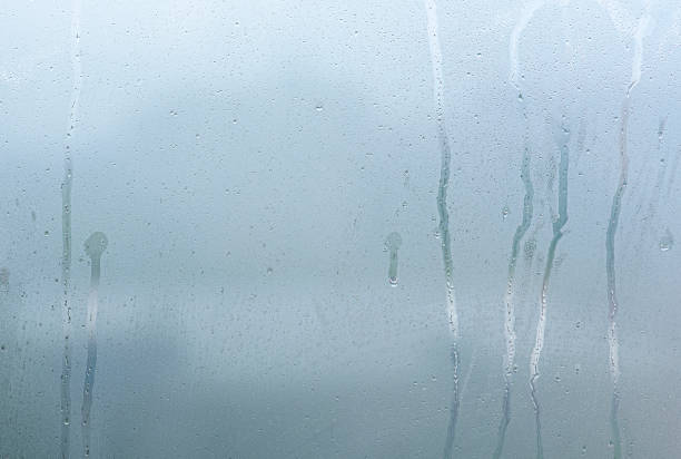 finestra con condensa di vapore e gocce dopo la pioggia, vetro bagnato come sfondo o consistenza - drop window water fog foto e immagini stock
