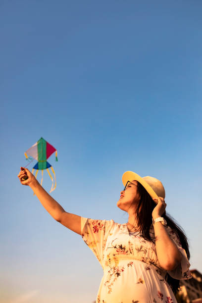 istock asian woman playing kite on the beach 1263412816