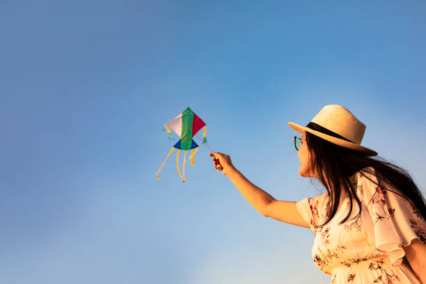 istock asian woman playing kite on the beach 1263412830
