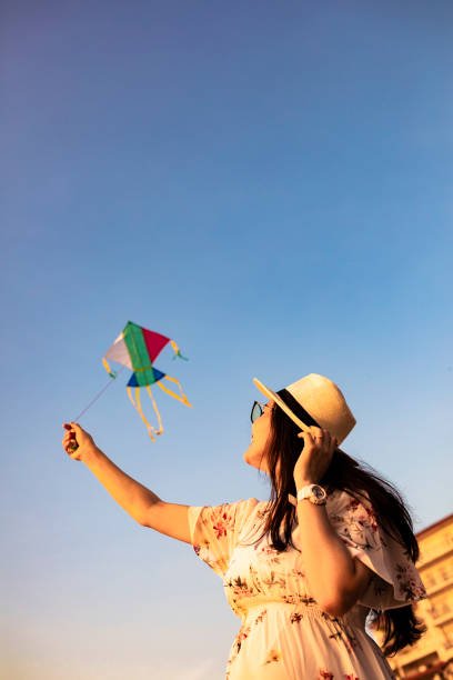 istock asian woman playing kite on the beach 1263412920