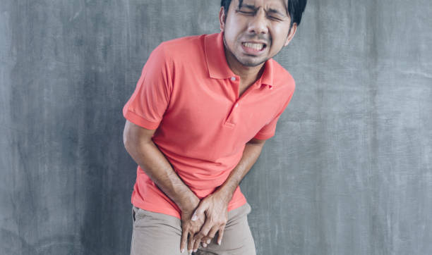 Urinary Tract Infection concept Painful Bladder Young asian holding his crotch on Cement wall background, Problems and health care concepts, Urinary Tract Infection concept Painful Bladder testis stock pictures, royalty-free photos & images