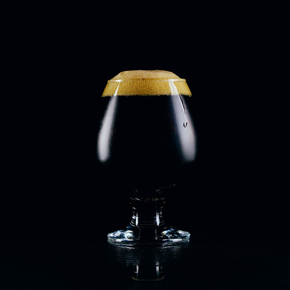 A glass of porter beer  on a dark background