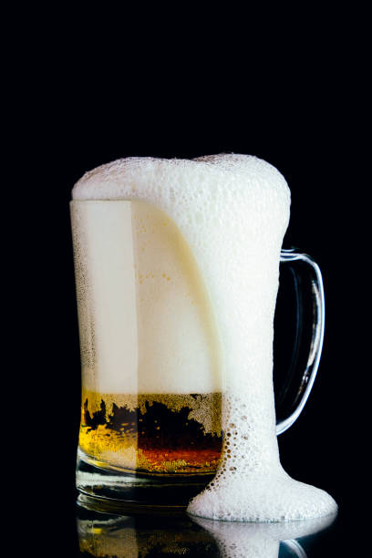Two pints of lager isolated on black.