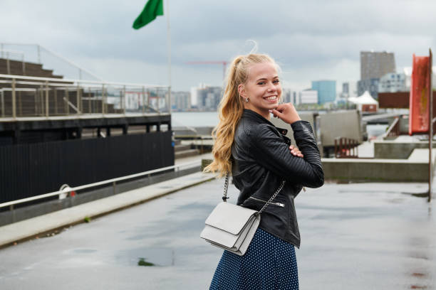 Friendly young woman smiling for camera on cloudy day in city stock photo