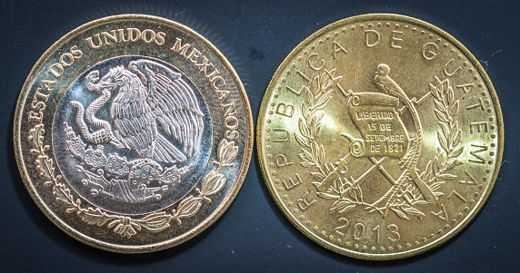 Guatemala City / Guatemala - Dec. 26, 2016 - Guatemalan Quetzal and Mexican Peso coins in detail