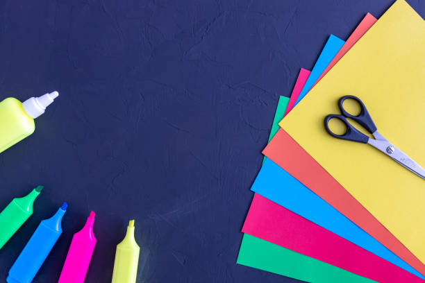 istock colored paper, scissors, glue, markers on a blackboard. back to school concept 1263429514