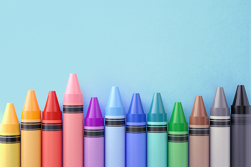 Colorful crayons over blue background. Horizontal composition with copy space.