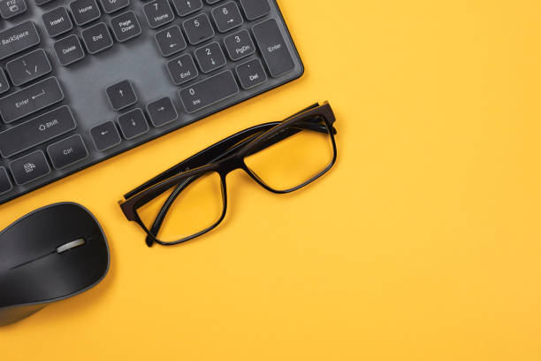 istock Pc mouse, keyboard and eyeglasses on yellow 1263433508