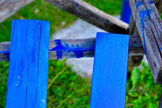 Freshly painted blue wooden planks on the grass