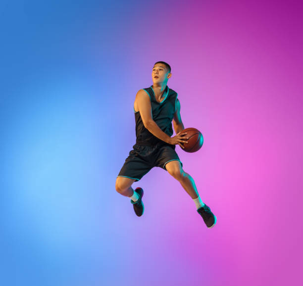 istock Young basketball player in motion on gradient studio background in neon light 1263433993