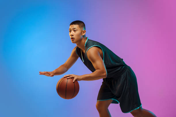 istock Young basketball player in motion on gradient studio background in neon light 1263434002