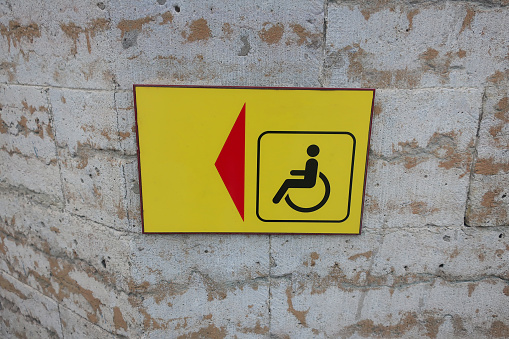 red arrow on yellow background indicating disabled parking space