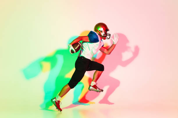 istock American football player isolated on gradient studio background in neon light with shadows 1263436392