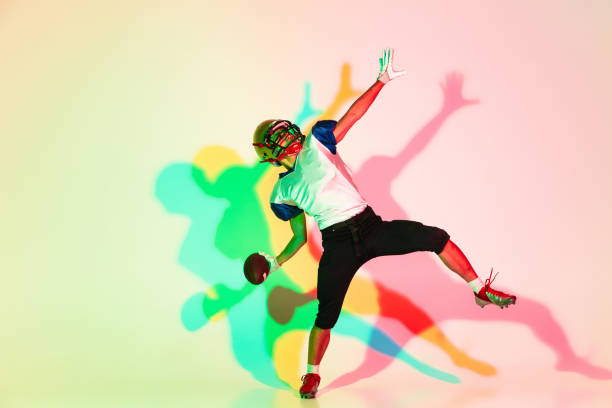 istock American football player isolated on gradient studio background in neon light with shadows 1263436398