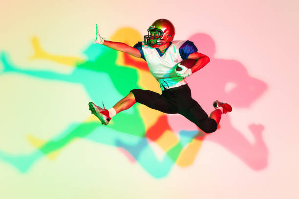 istock American football player isolated on gradient studio background in neon light with shadows 1263436418