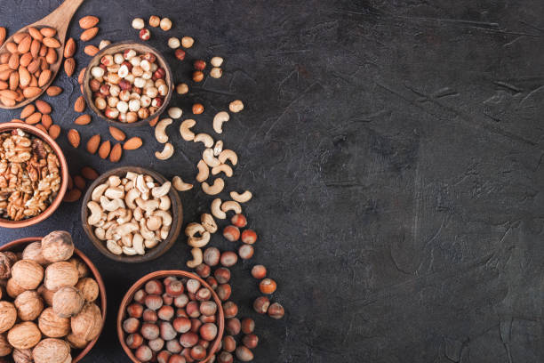 istock Different nuts in dishes, walnuts, hazelnuts, cashews and almonds 1263439198