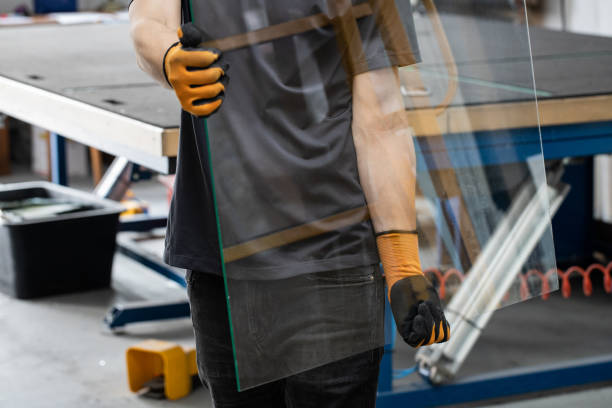 Glass factory, Worker carrying glass panes