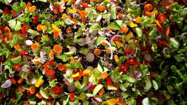 freeze motion of flying fresh vegetable mix - lettuce endive abstract leaf imagens e fotografias de stock