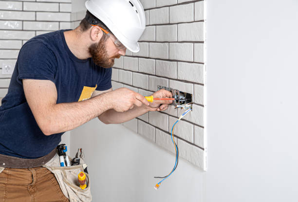 electrician builder at work, installation of sockets and switches. professional in overalls with an electrician's tool. against the background of the repair site. - electrical contractor imagens e fotografias de stock