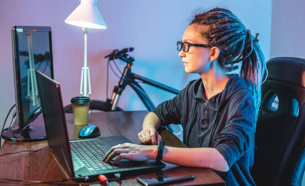 Modern young female programmer is writing program code on a laptop at home. Remote work in the IT profession stock photo