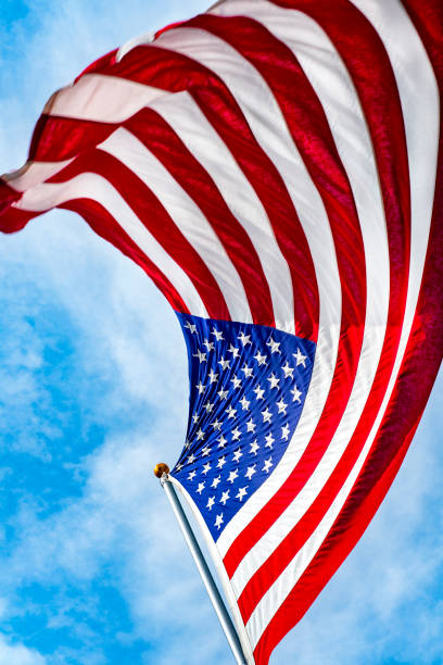 istock Looking up at American flag blowing in wind 1263447604