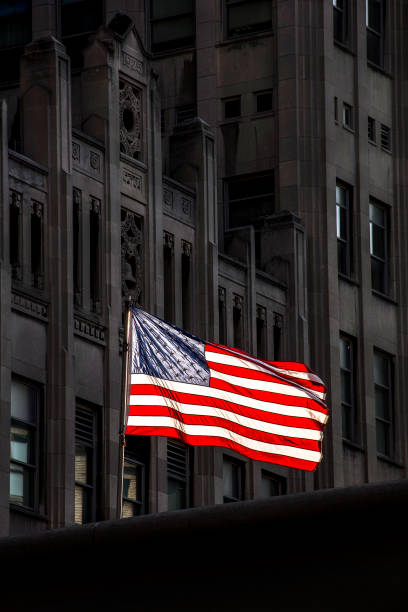 istock American flag back lit blowing in wind dark background 1263447611