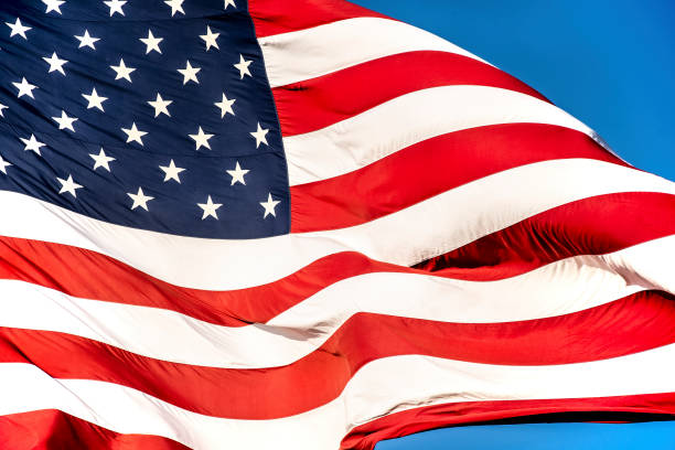 istock Closeup large American flag blowing in wind 1263447625