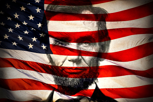 Bandera estadounidense superpuesta sobre el retrato de Abraham Lincoln photo
