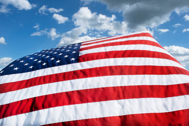 istock Closeup large American flag blowing in wind 1263447866