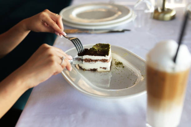 istock Young woman eating cake next to coffee 1263451571