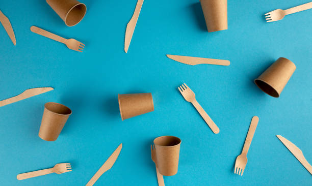 istock Wooden forks, knives and paper glasses pattern on blue background 1263451699