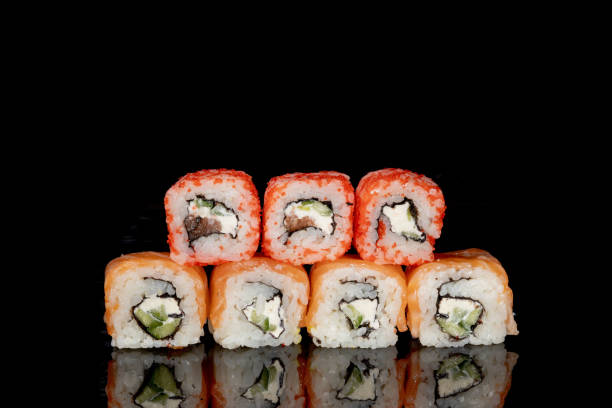 istock Philadelphia roll with salmon, cheese and cucumber on a black background with reflection. Sushi Philadelphia 1263452814