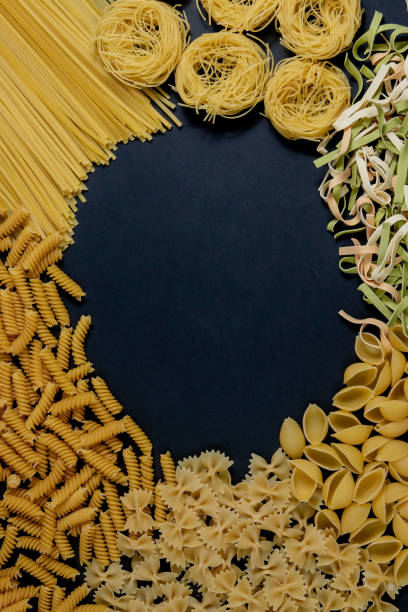 istock Assortment of different types of pasta dry on black background. 1263452835