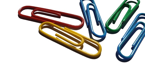 Coloured paper clips on white background