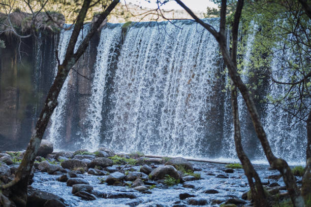 istock Small waterfall surrounded by rocks and trees in autumn. bucolic image 1263456099