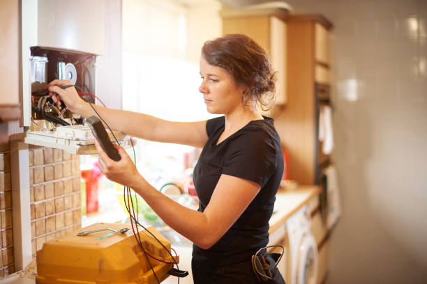 engenheiro de aquecimento feminino servindo uma caldeira - plumber electrician trainee female - fotografias e filmes do acervo