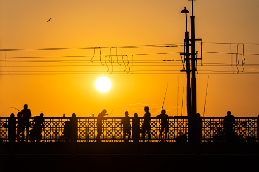 People at sunset on the Galata Bridge.