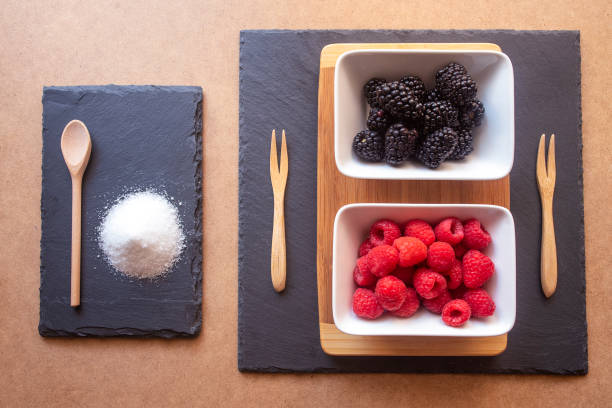 istock Forest fruits, raspberries, blackberries and strawberries in a rectangular plate on a brown and shaded base. With wooden forks and a slate plate. 1263462428