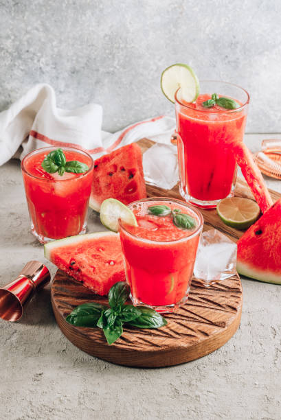 istock Watermelon lemonade with lime and fresh basil leaves on concrete background. Refreshing summer drink 1263463500