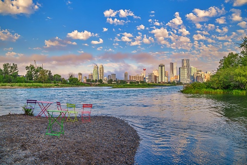 A beautiful cloudy sky over the Bow river and the downtown Calgary skyline in the summertime.