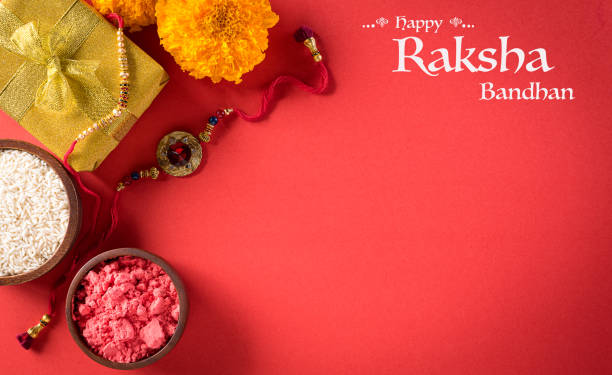 Raksha Bandhan, Indian festival with beautiful Rakhi and  Rice Grains on red background.  A traditional Indian wrist band which is a symbol of love between Sisters and Brothers. Raksha Bandhan, Indian festival with beautiful Rakhi and  Rice Grains on red background.  A traditional Indian wrist band which is a symbol of love between Sisters and Brothers. raksha bandhan stock pictures, royalty-free photos & images