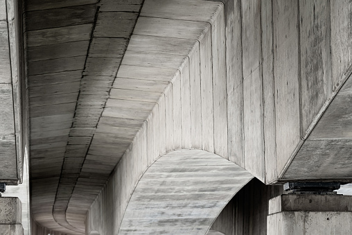 Concrete supports underneath a bridge of a motorway (M3) which stretches across a river (River Lagan).  Belfast, Northern Ireland.