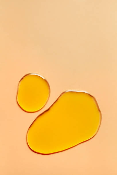 orange kupfer gold klar transparent wasser flüssige kosmetische toner gel kühlung tonic lotion schmierstoff mehrfarbigen hintergrund - massageöl stock-fotos und bilder