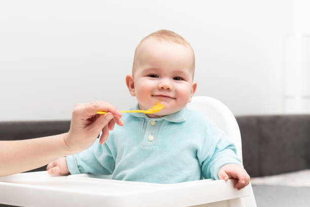 istock Mother Feeding Baby With Spoon 1263476578