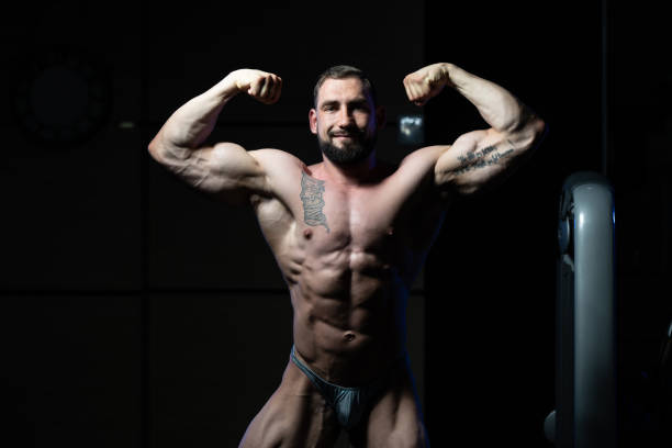 istock Muscular Men Is Hitting Rear Double Bicep Pose 1263476610